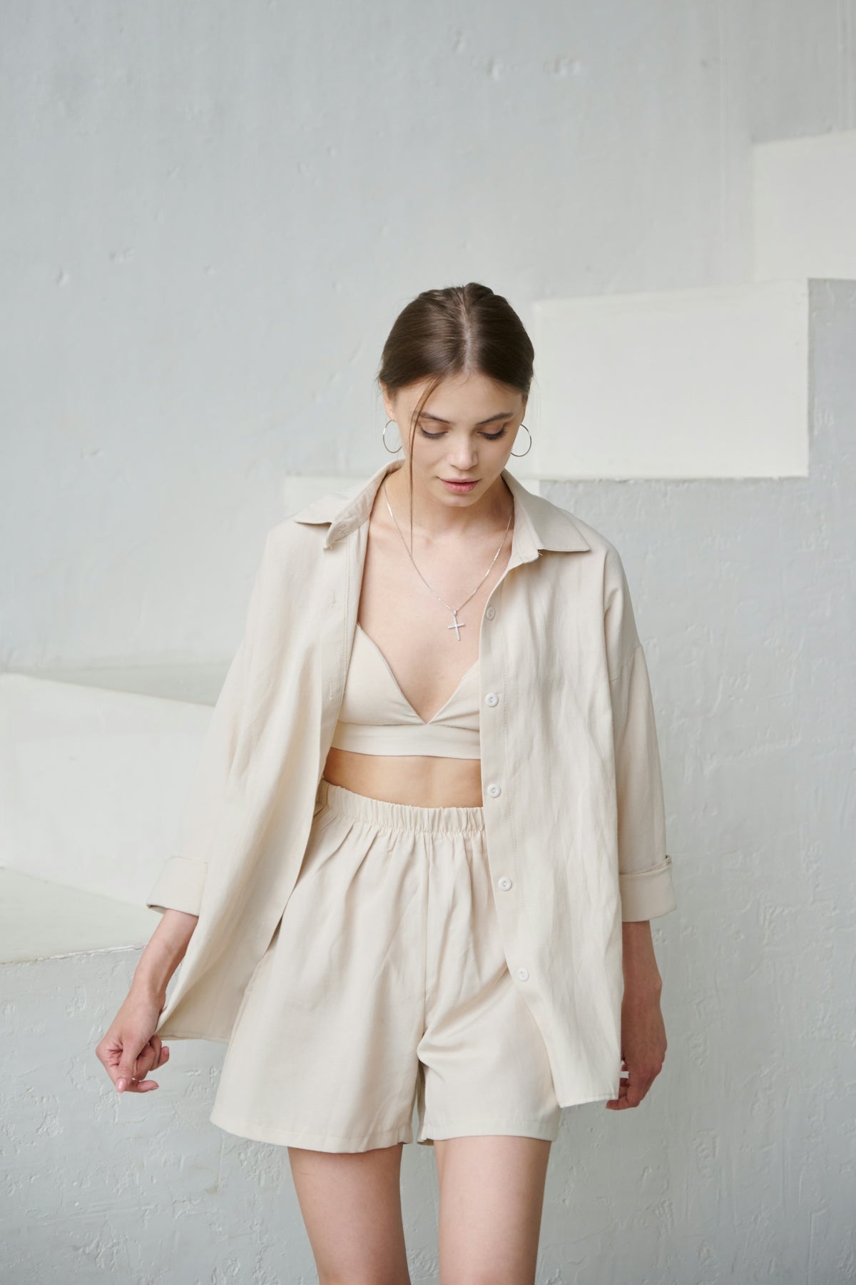 a woman in shorts and a jacket standing in front of a wall